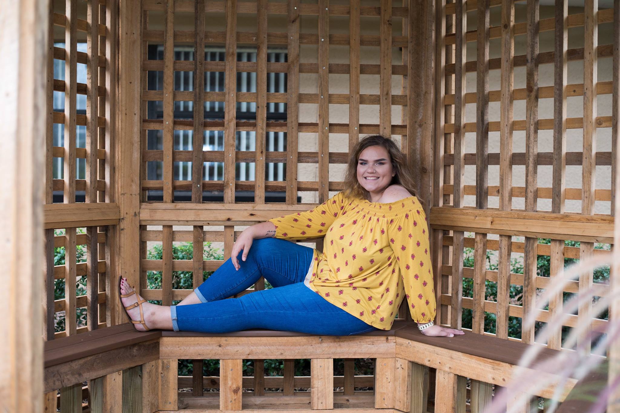 Senior relaxing inside wooden lattice gazebo at public park