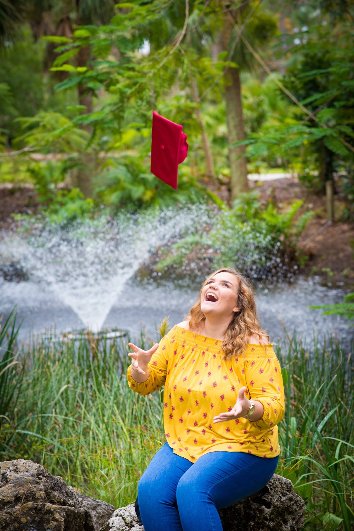 Senior portrait at botanical garden with fountain in Tampa Bay area